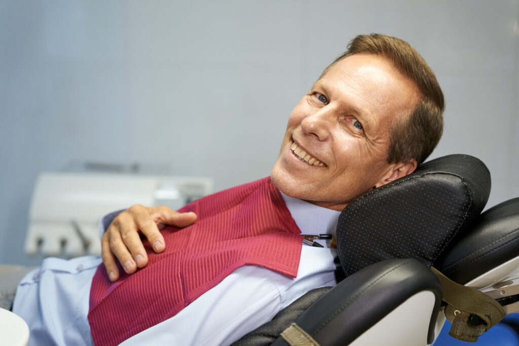 Middle-aged male dental patient smiling with perfect teeth