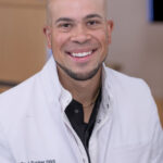 Dr. J. Tucker, DDS at New Day Dental & Medical Aesthetics, portrait in white dental coat