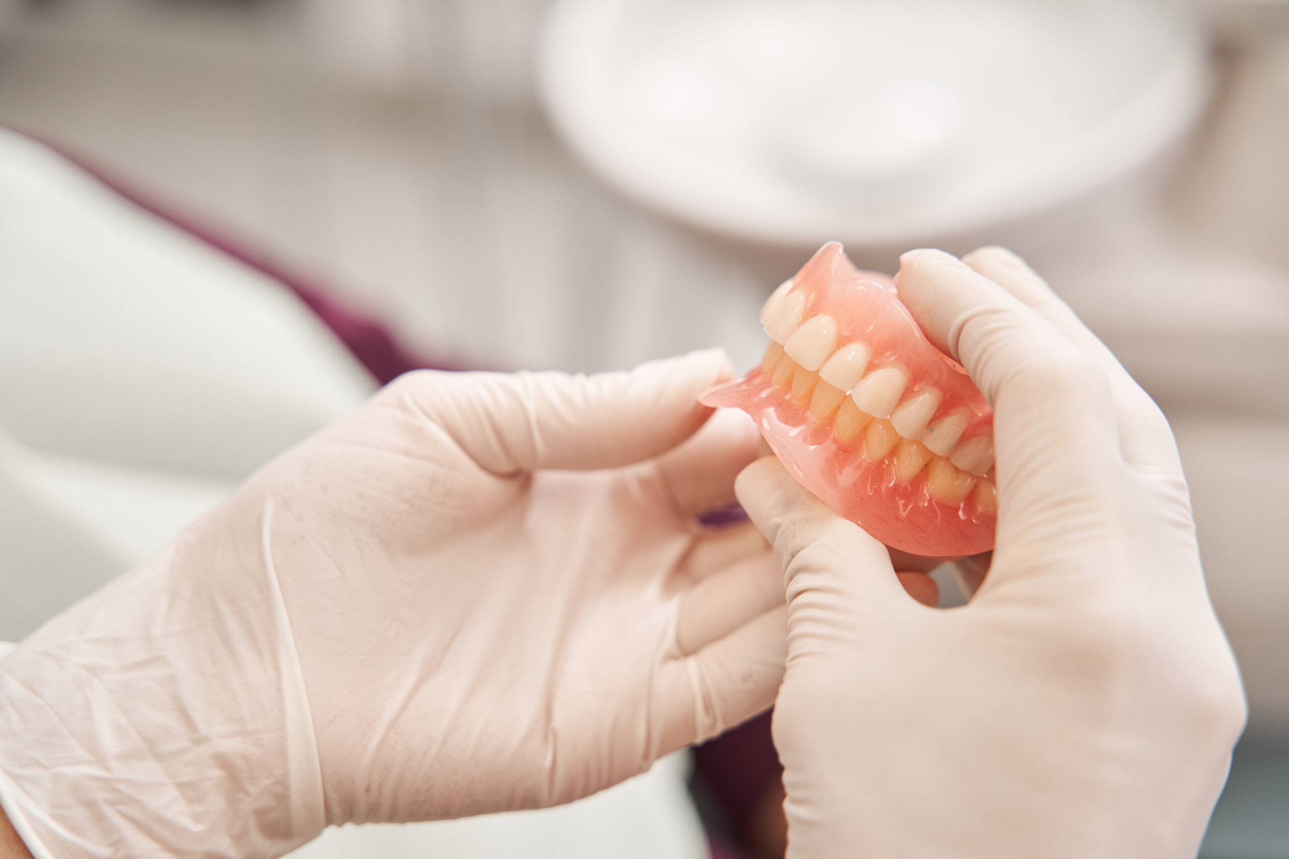Dentist holding a set of custom dentures