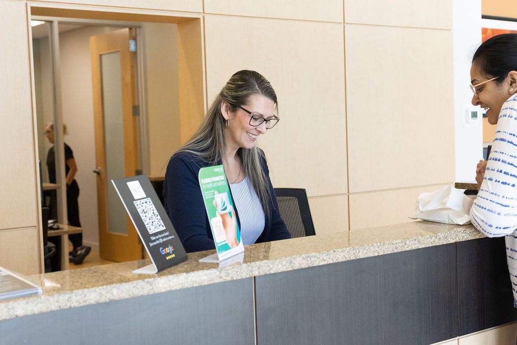 Sunrise Dental Cary receptionist smiling at front desk greeting a patient