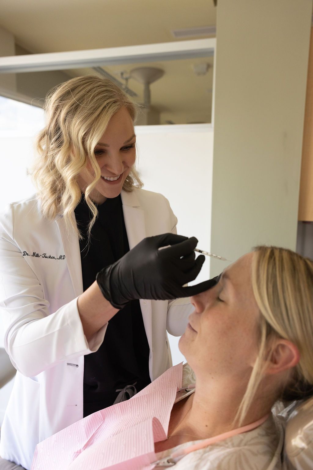 Dr. Mills-Tucker explains dental procedure to patient at Sunrise Dental Cary treatment room.