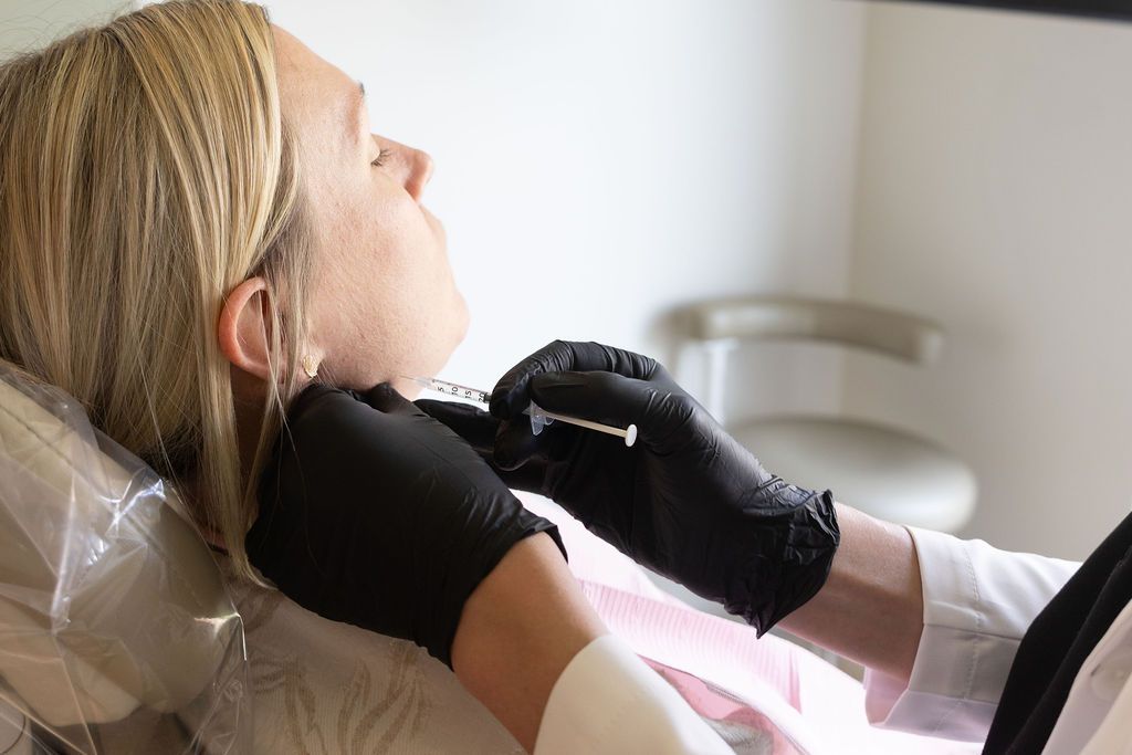 Dentist in black gloves examining patient's teeth during dental procedure